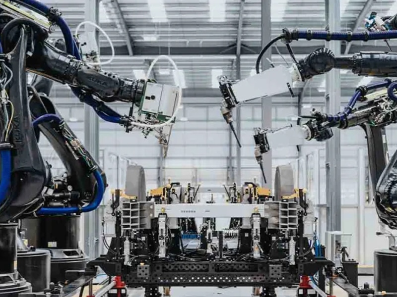 Industrial factory interior showing robots working an an automotive engine.